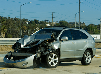 silver small suv on the side of the road after a car accident, the front end is smashed