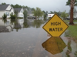 flooded street with high water sign